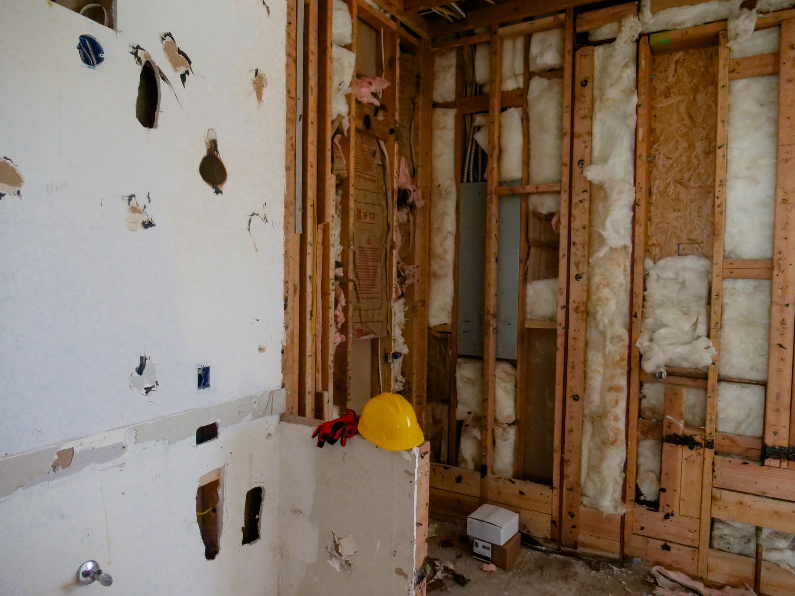 Illustrative renovation interior with exposed wall studs, insulation, and electrical boxes